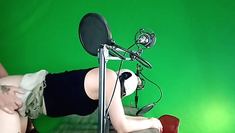 A redheaded girl with green screen is showing off her body